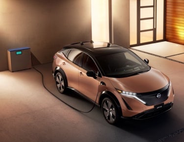 Nissan ARIYA plugged-in and charging outside a home | Tom Naquin Nissan in Elkhart IN